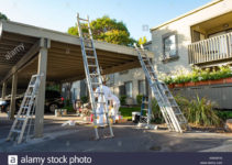 Workers Lean Ladders On A Carport While Preparing To Paint Picture Sample in Metal Carport Paint